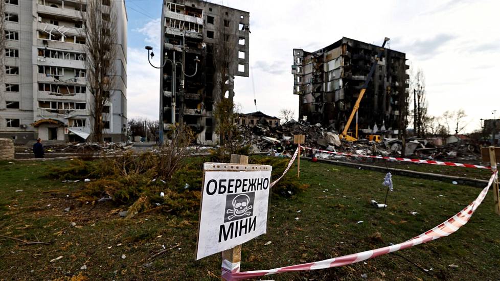 Kyltti varoittaa venäläisten miinoista pommituksissa tuhoutuneiden rakennusten edessä Ukrainan Borodjankassa Kiovan alueella huhtikuussa 2022. 