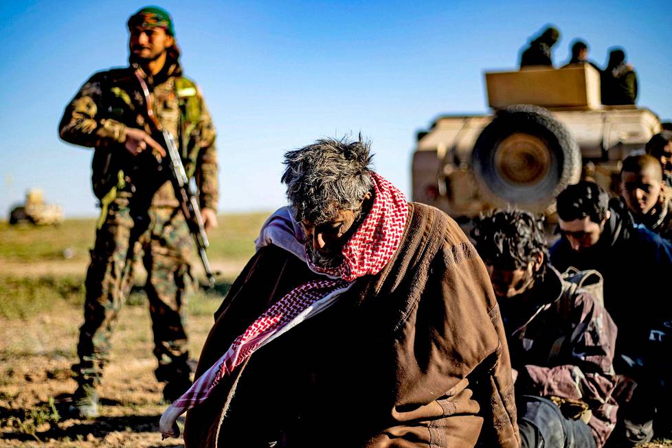 Maaliskuussa 2019 SDF-sotilas vartioi Baghouzin lähellä Isis-taistelijoiksi epäiltyjä miehiä.