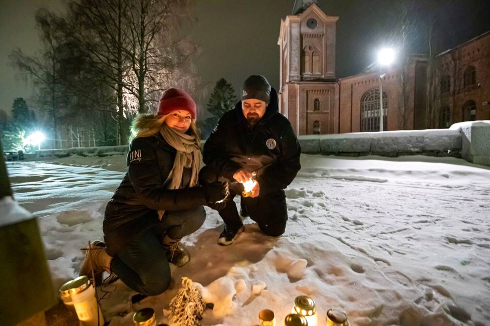 Tony Sivula sytyttämässä kynttilää haudalle vaimonsa Heidin kanssa.