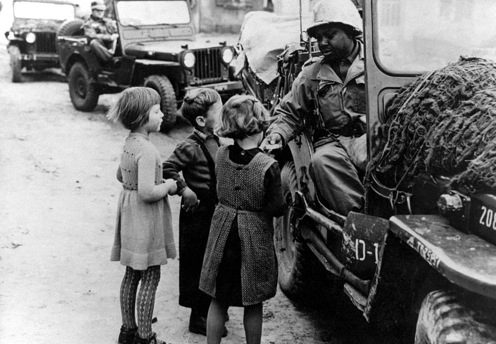 Berliiniläisiä lapsia ja amerikkalaissotilas.