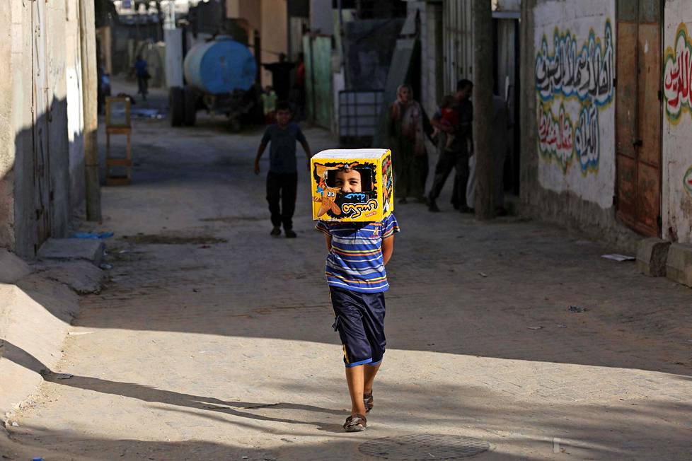 Lasten leikkiä. Pikkupoika pelleili laatikko päässä Gazan palestiinalaisalueilla tiistaina.