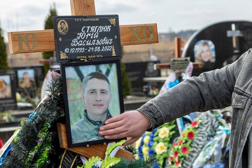Juri Stiahliukin veli Oleksandr kävi koskettamassa ukrainalaiseen tapaan veljensä kuvaa haudalla.